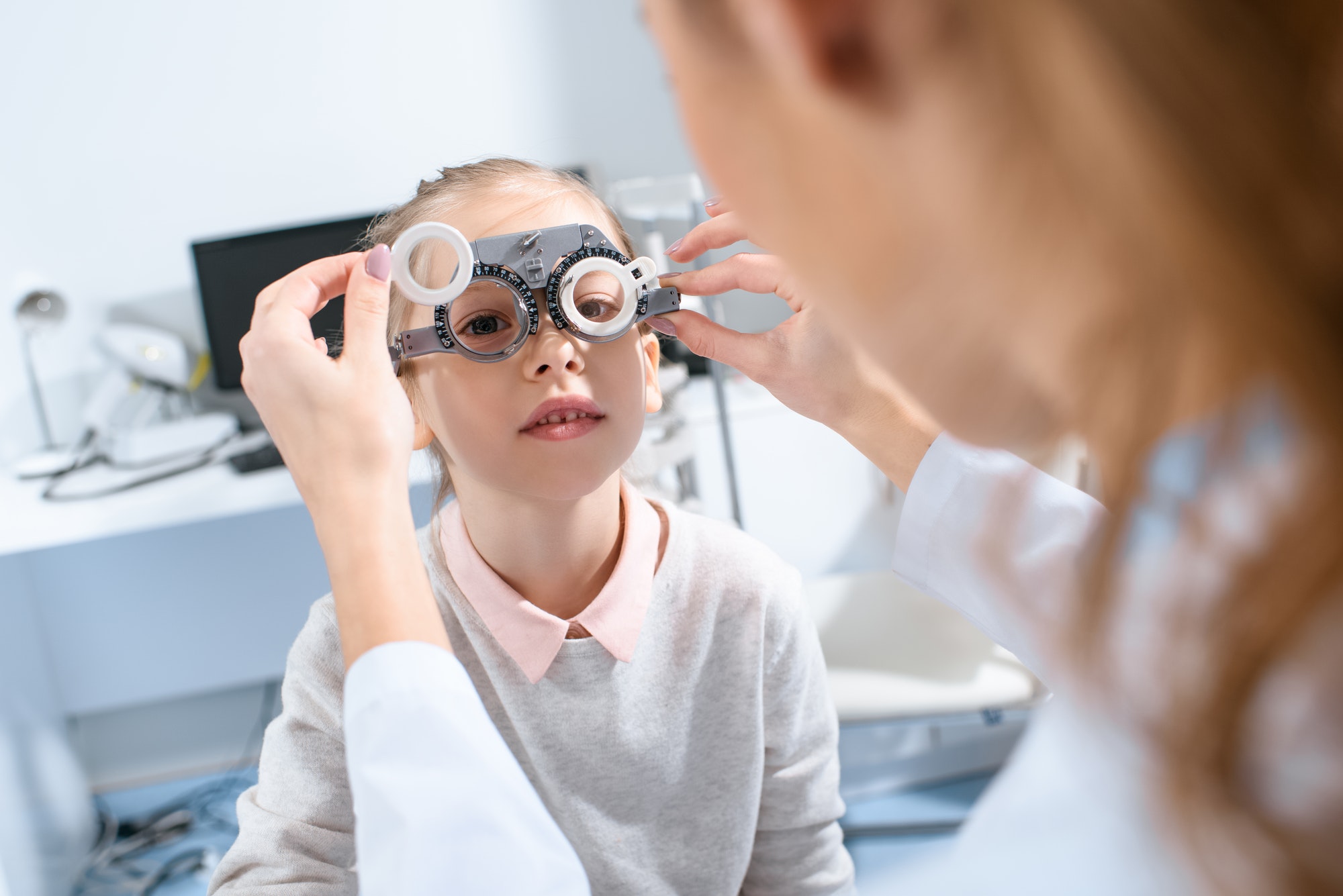 selective-focus-of-ophthalmologist-examining-kid-eyes-with-trial-frame-in-clinic.jpg
